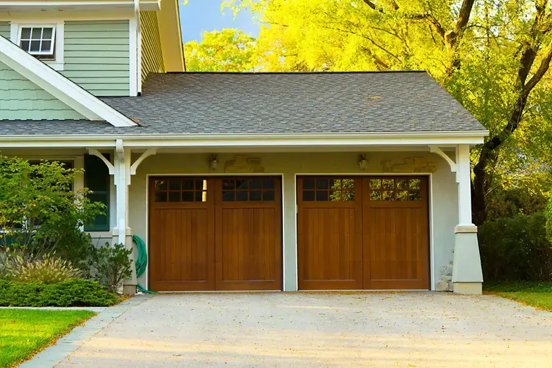 Freshly painted exterior garage with wood doors and green siding on a Denver home